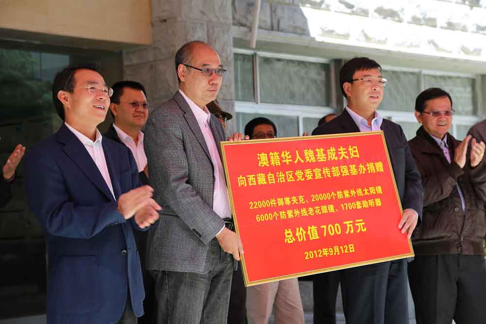 2012年9月，魏基成伉儷向西藏自治區捐贈總價值700萬元人民幣的物資