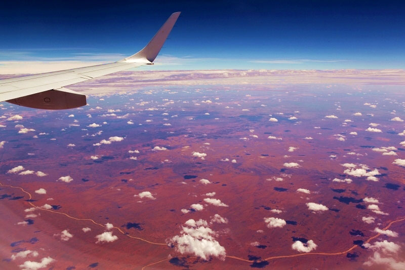 飛抵烏魯魯上空，云朵和紅土如壯觀的巨大棋盤（攝影 馬小龍）