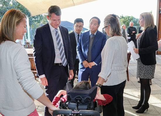 新州州長邁克?貝爾德（左二）、玉湖集團董事長黃向墨（左四）與病友家庭交談