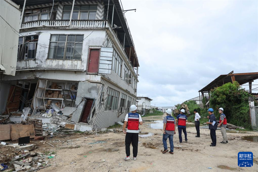 1月1日，在瓦努阿圖維拉港，中國地震局專家組成員查看房屋受損情況。新華社記者 龍雷 攝